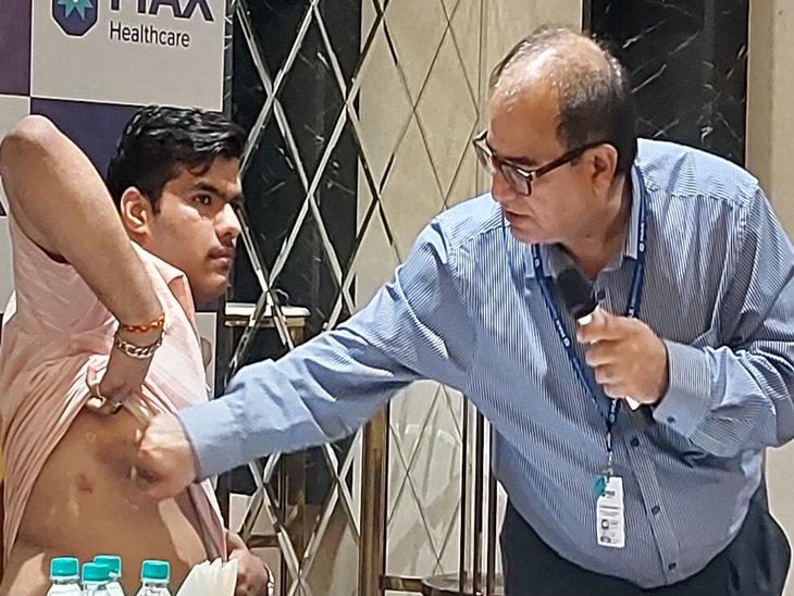 एडन मलिक के शरीर पर रोबोटिक सर्जरी के निशान दिखाते हुए डॉ. रजनीश मल्होत्रा।