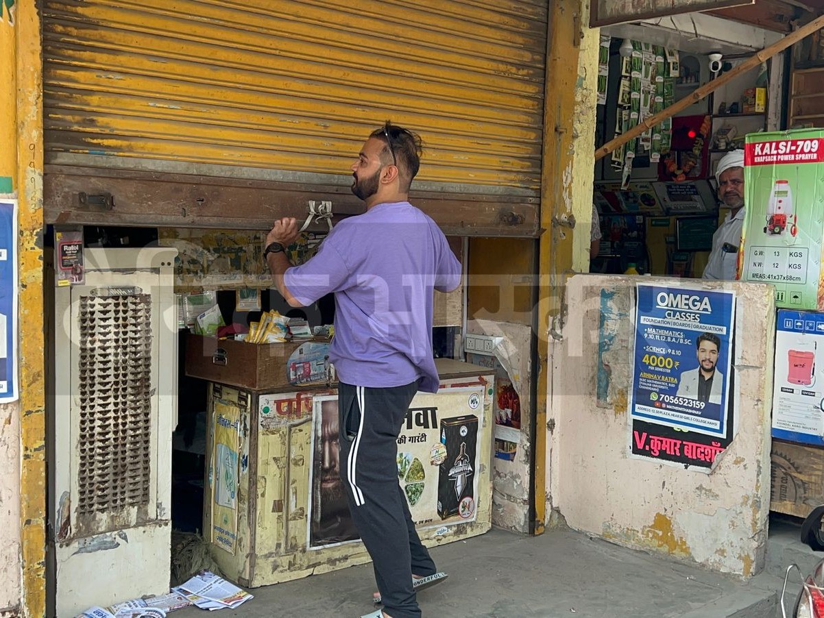 बीज की दुकान खोलते हुए दुकानदार।