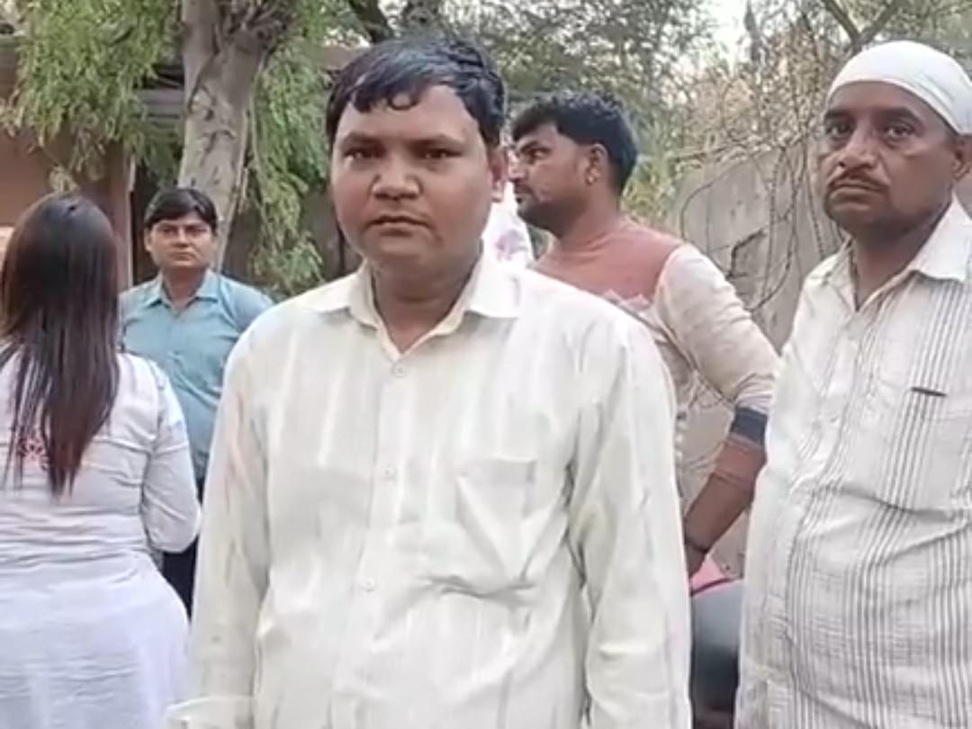 सफेद शर्ट में खड़े बच्चों के पिता लक्ष्मण सिंह।