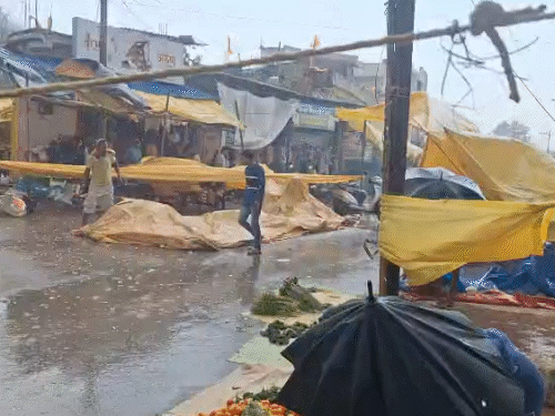 तेज आंधी-तूफान के बीच बाजार में उड़े तिरपाल, दुकानदारों के सामान भीग गए।