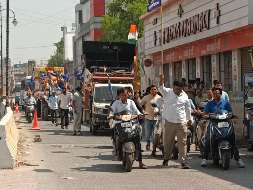 हाथ में झंडा लिए और डीजे के साथ शोभा यात्रा निकालते हुए लोग।