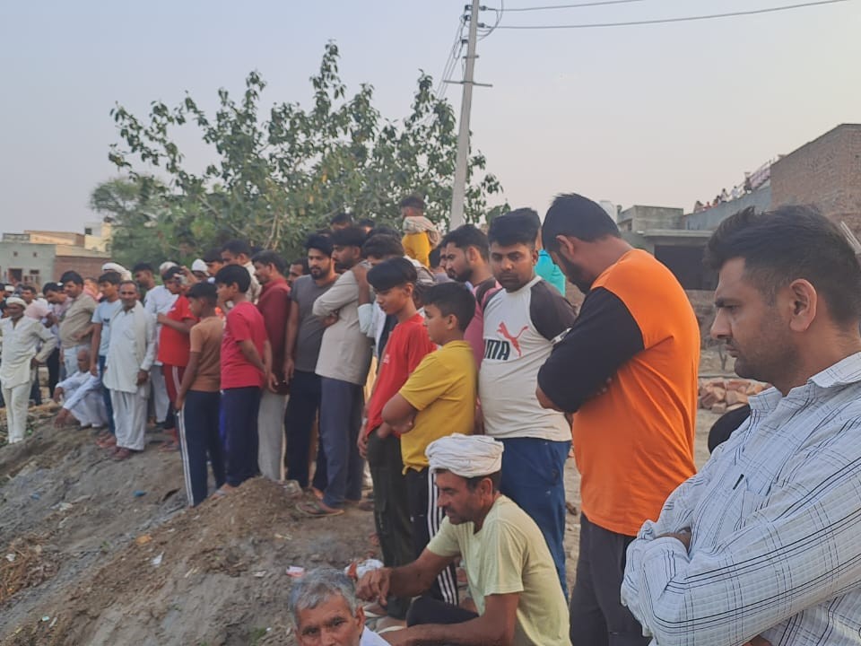 ਉਹ ਟੀਮ ਨੂੰ ਵੇਖਦਿਆਂ ਪਿੰਡ ਵਾਸੀ ਜੋ ਪਿੰਡ ਦੇ ਬਾਸ ਦੇ ਤਲਾਅ ਵਿੱਚ ਡੁੱਬੇ ਹੋਏ ਵਿਅਕਤੀ ਨੂੰ ਬਾਹਰ ਕੱ. ਦੇ ਹਨ.