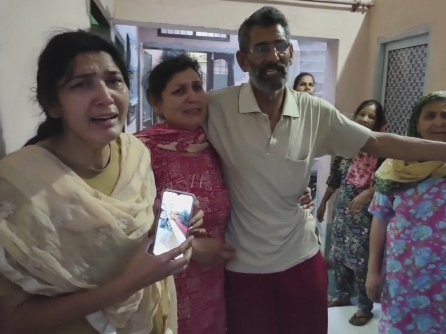 परिजन मृतक की फोटो दिखाते हुए।