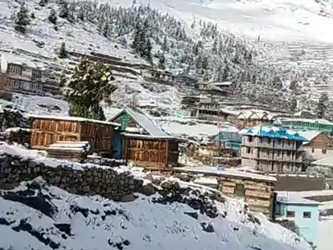 घरों पर बर्फ की सफेद चादर बिछी हुई।