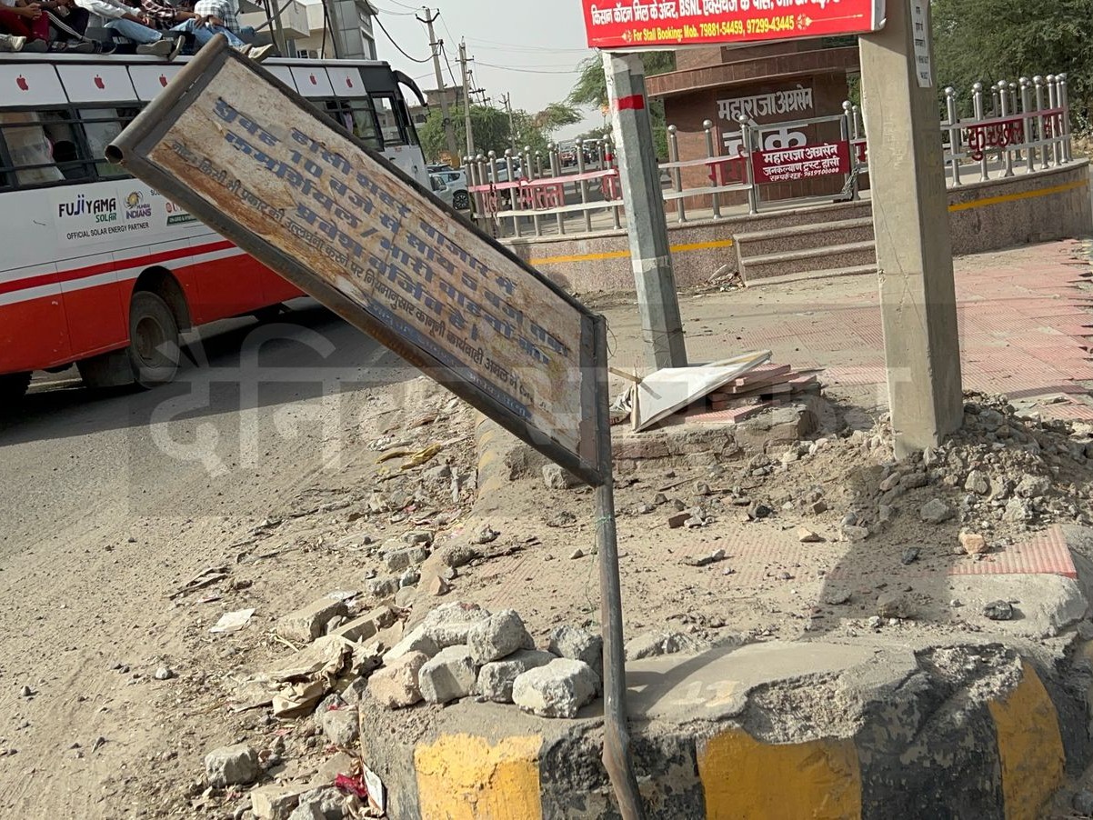 वाहन की टक्कर से झुका नो एंट्री बोर्ड।