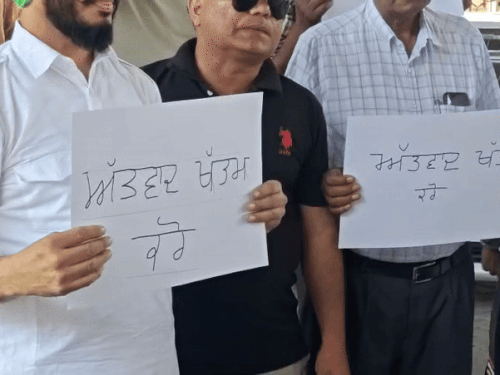 हाथ में तख्तियां लेकर खड़े टैक्सी यूनियन के मेंबर।