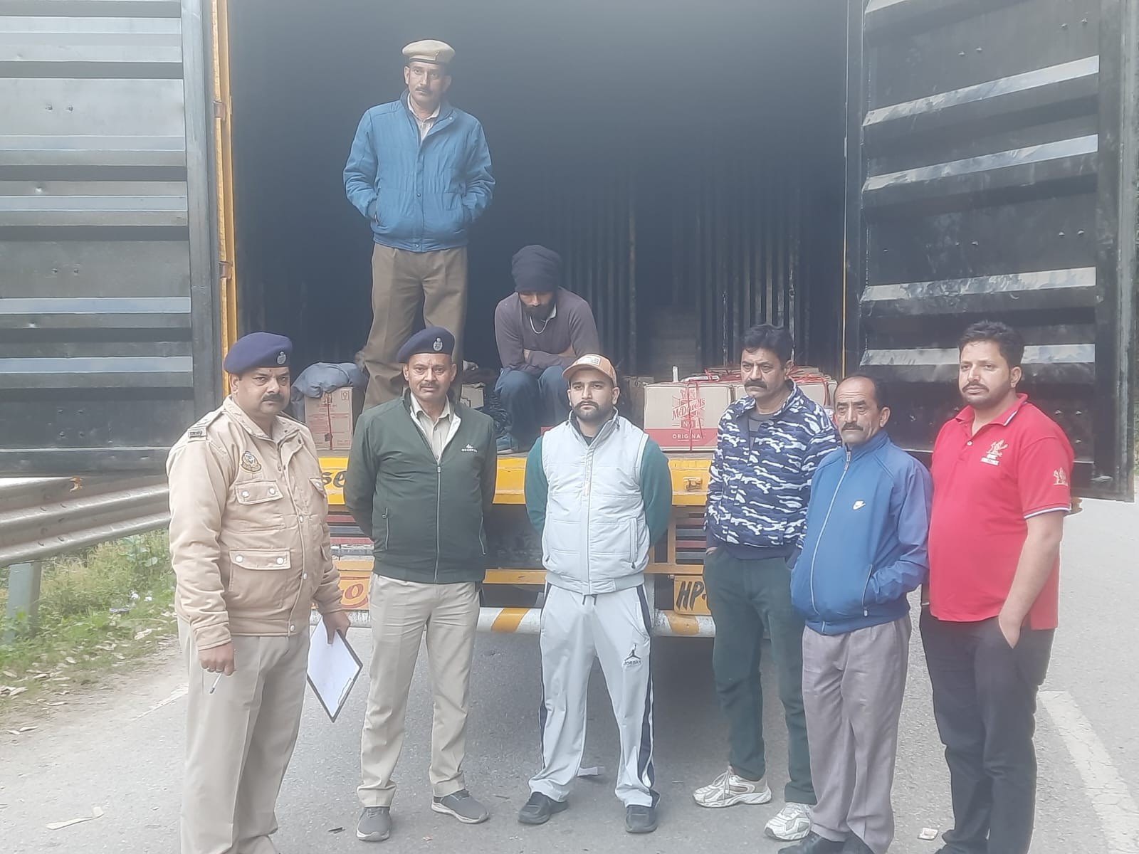 पुलिस द्वारा गिरफ्तार किया ट्रक ड्राइवर और जब्त की गई अवैध शराब।