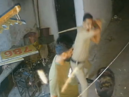 युवकों की पिटाई करते पुलिसकर्मी।