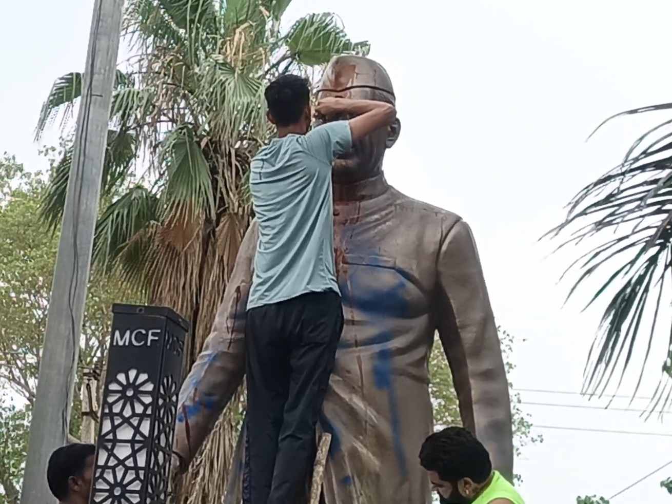 Local people cleaning the paint on the statue of first Prime Minister Pandit Jawaharlal Nehru.
