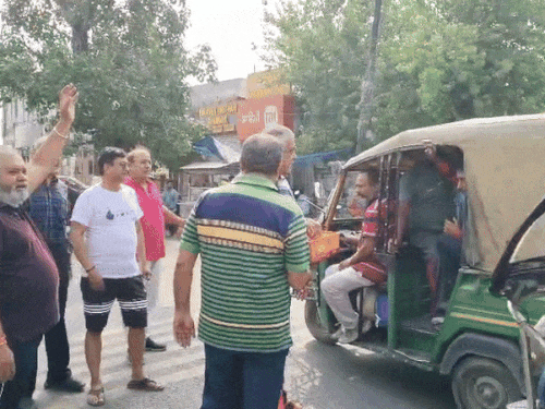 लोगों को लड्डू बांटते हुए लोग।