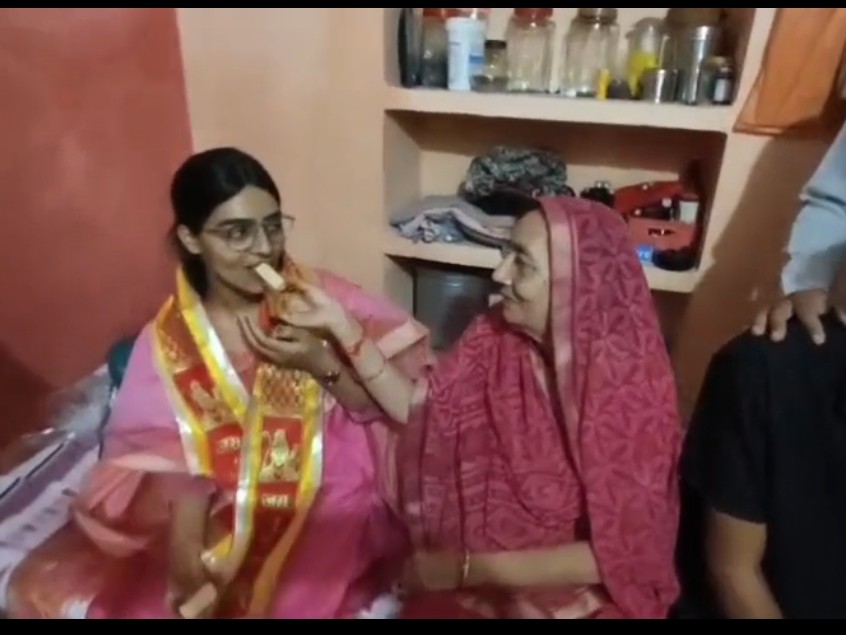 बेटी की सफलता पर मां ने खिलाई मिठाई।