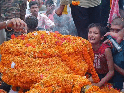 शहीद पिता के पार्थिव शरीर से लिपटकर रोता बेटा।