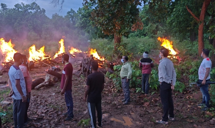 Policemen burning the dead body of Naxalites in Narayanpur