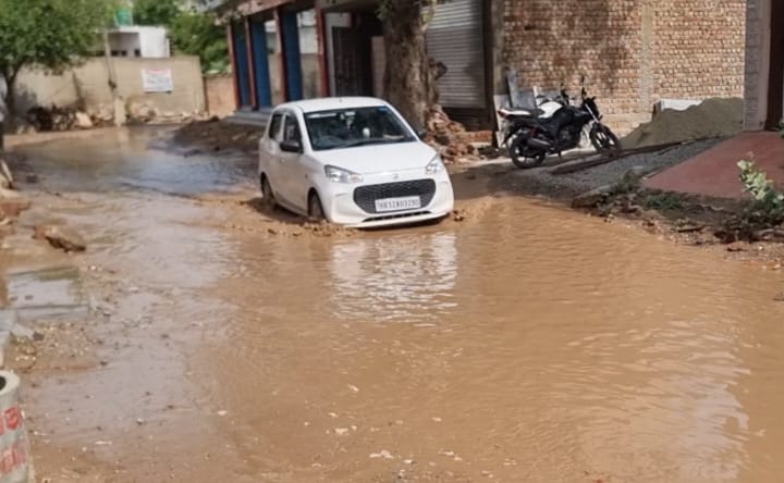 बरसात के पानी से गुजरती हुई कार