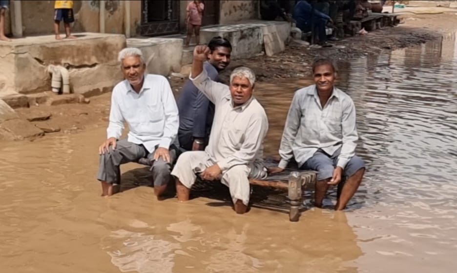 सड़क के बीच पानी में खटोला डालकर विरोध जताते हुए मोहल्ला निवासी