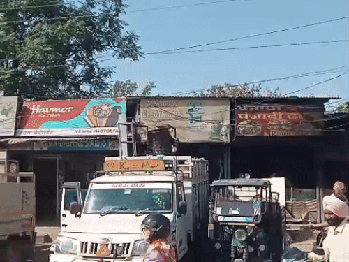 दुकानों के अंदर से सामान निकालते दुकानदार।