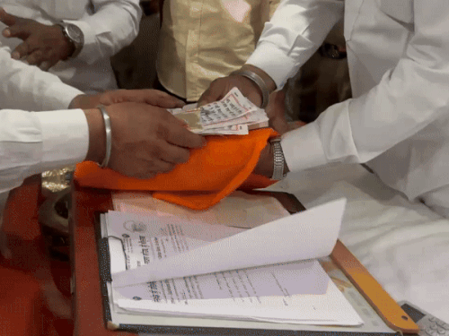 आरोपी की तरफ से गुटका साहिब फाड़े गए अंगों को समेटते हुए एसजीपीसी कर्मी। - Dainik Bhaskar