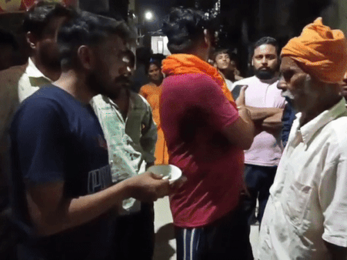 आइसक्रीम विक्रेता को पकड़ कर कुल्फी में मिली छिपकली दिखाते इलाके के लोग।