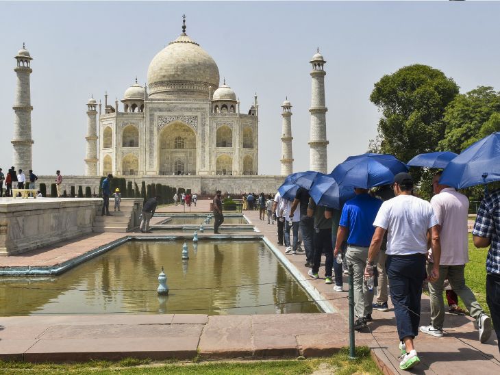 UP के आगरा में तेज धूप से बचने के लिए पर्यटक छाता लेकर पहुंचे। गर्मी के कारण पर्यटकों की संख्या में कमी आई है।