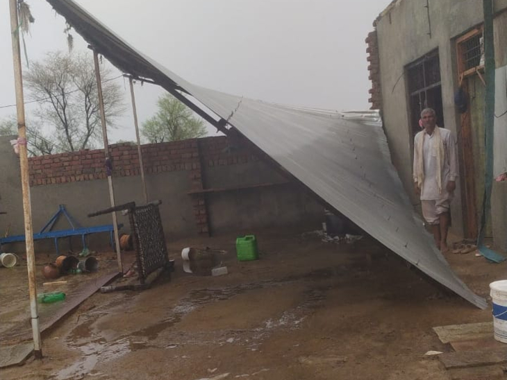 जनूथर में आंधी के बाद मकान के ऊपर लगा टीनशेड उड़ा।