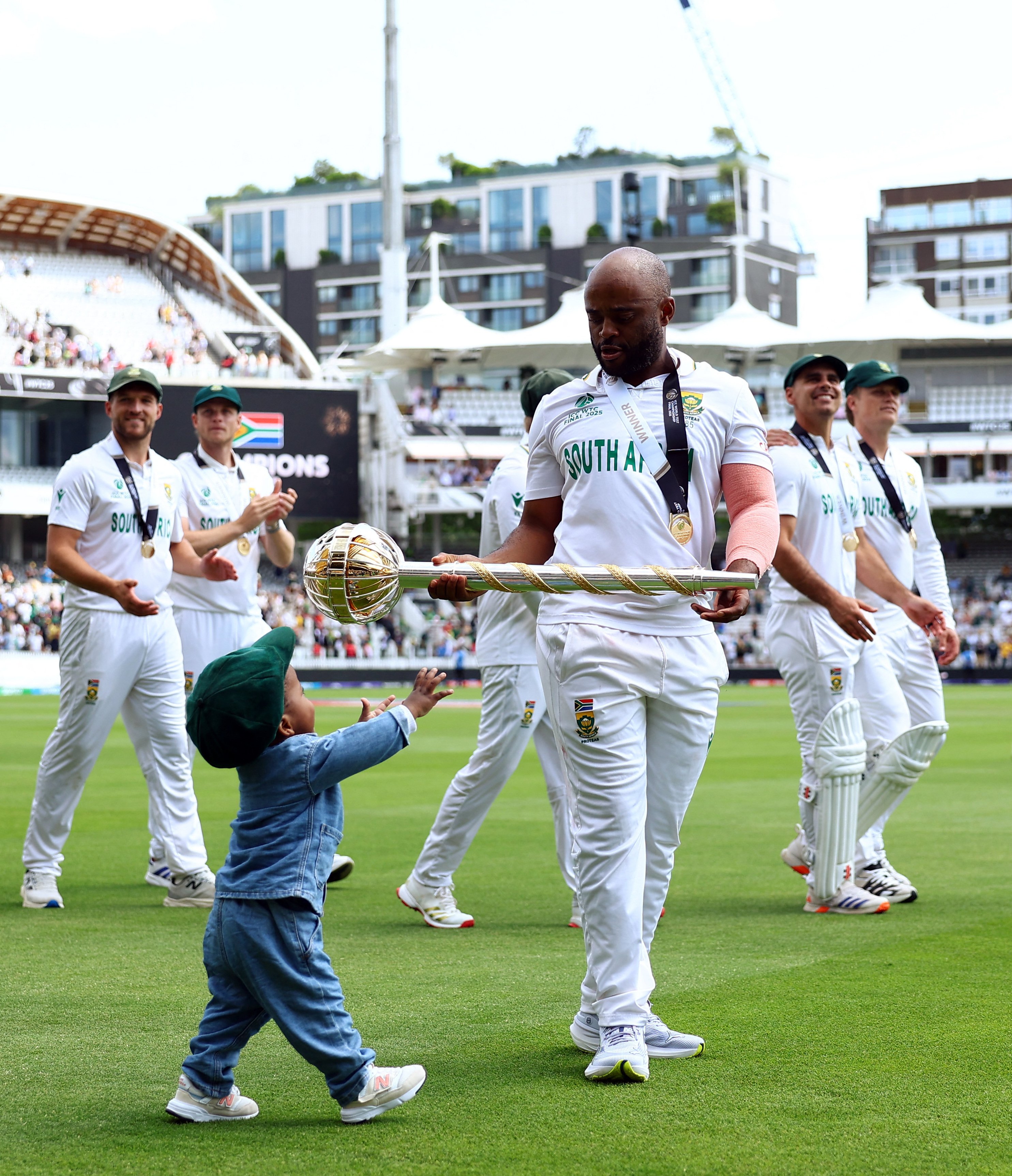 WTC जीतने के बाद अपने बेटे को टेस्ट की गदा देते साउथ अफ्रीकी कप्तान टेम्बा बावुमा।