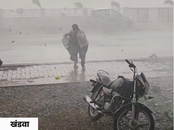 खंडवा: तेज आंधी- बारिश के बीच बचने के लिए भागते दंपती।