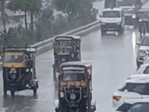 सीकर के स्टेशन रोड एरिया पर बारिश के दौरान गुजरते वाहन।
