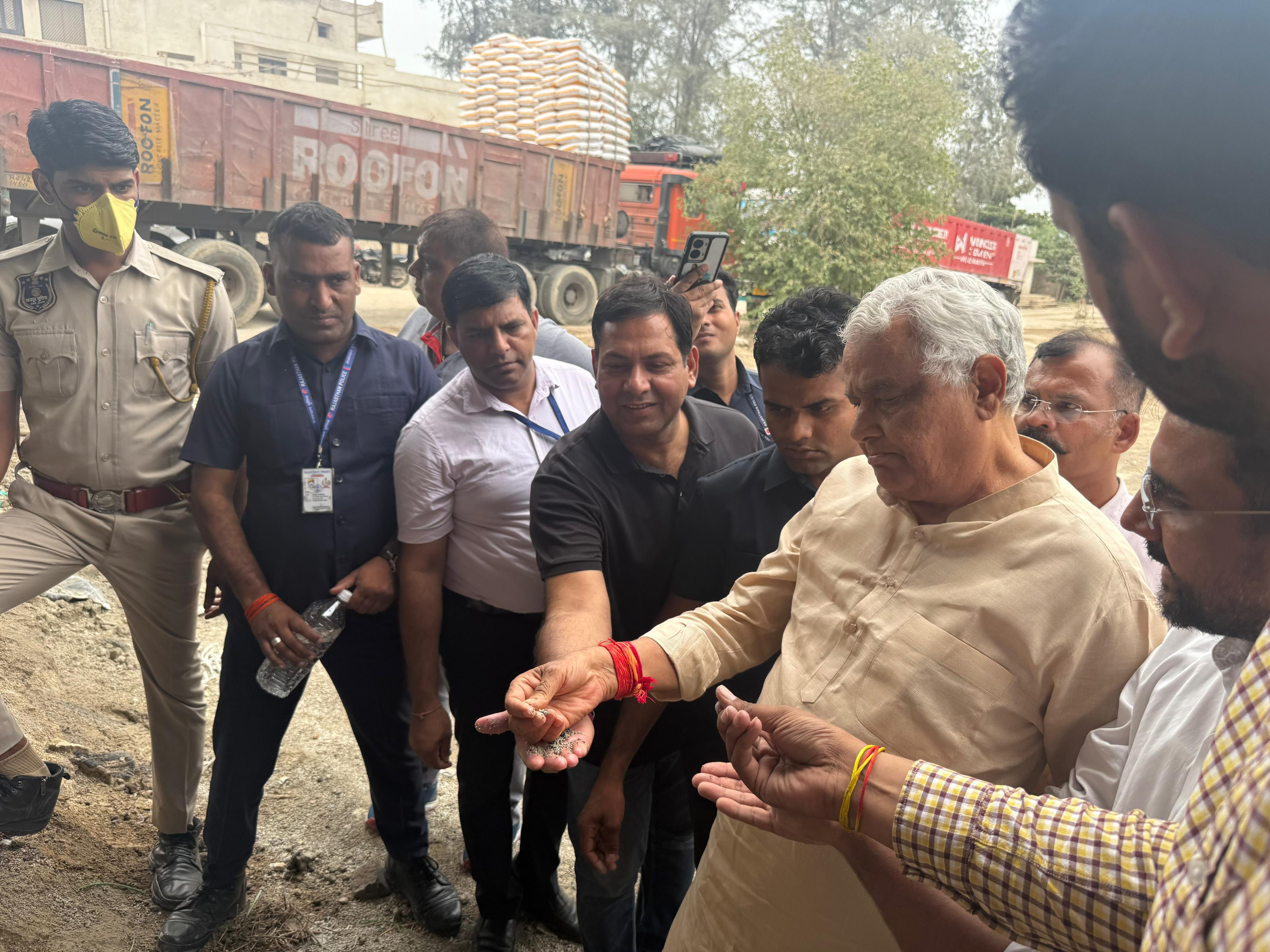 उमरड़ा स्थित पटेल फास्फोरस कंपनी में खाद को हाथ में लेकर जांच करते हुए कृषि मंत्री।
