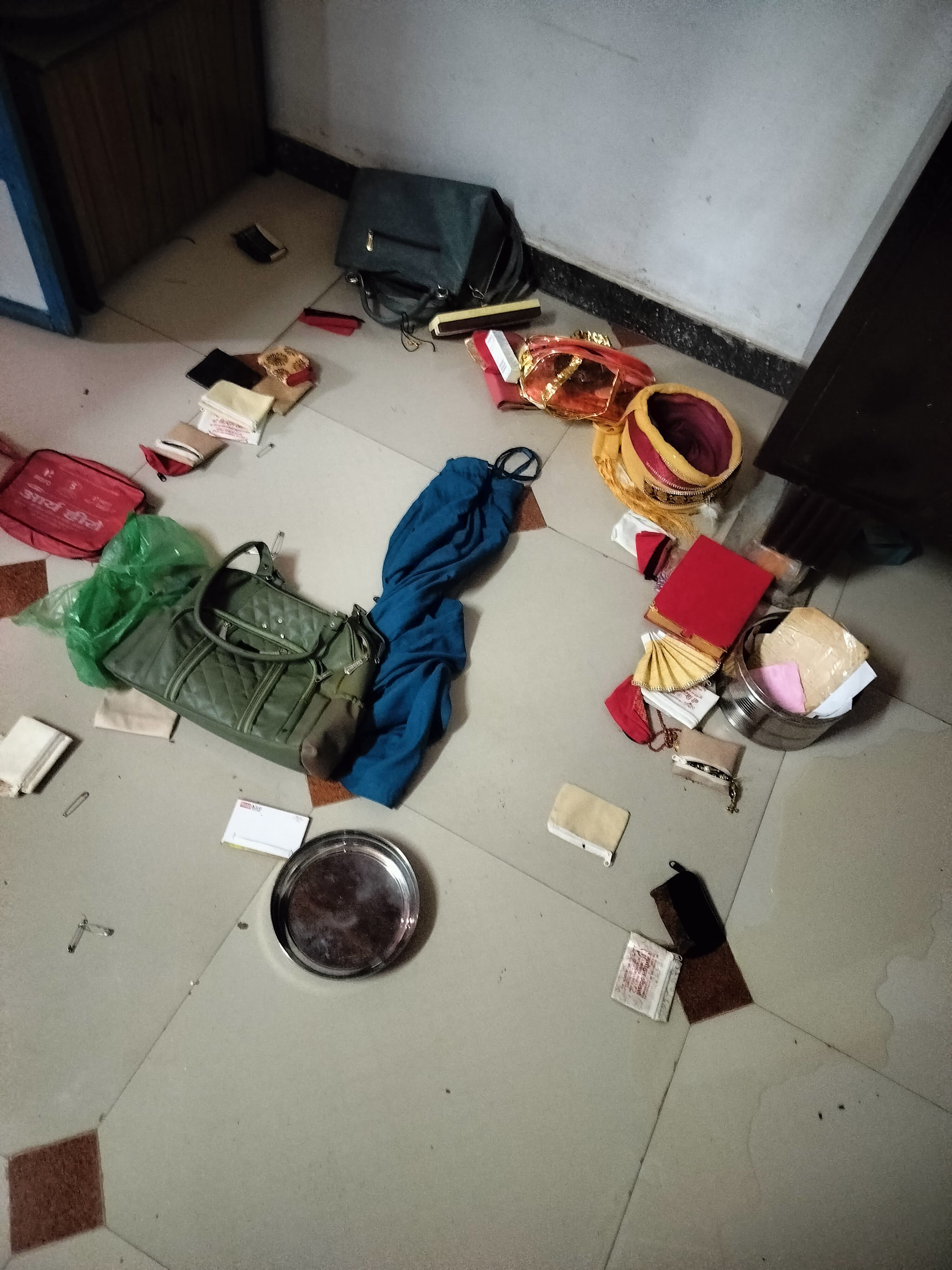 घर के कमरे में बिखरा हुआ अलमारी का सामान।