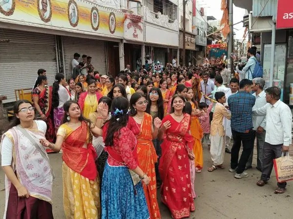 श्रद्धालु रथयात्रा में भजनों पर नृत्य करते हुए शामिल हुए।
