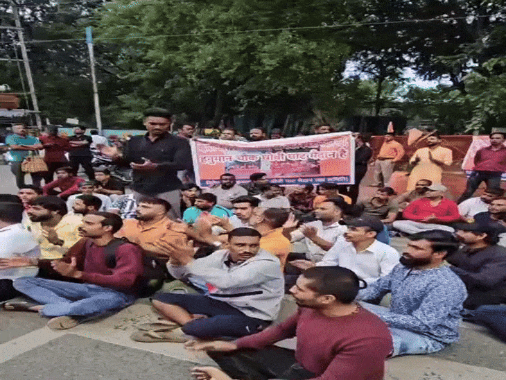 जमीन पर बैठ कर प्रदर्शन करते हुए।