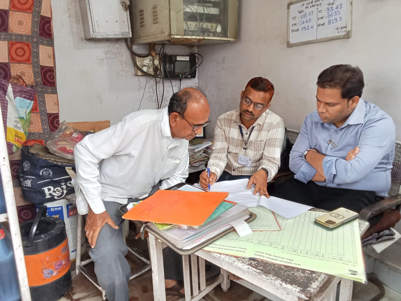 ऑफिस में दस्तावेज को देखते हुए खाद्य-राजस्व विभाग के लोग।