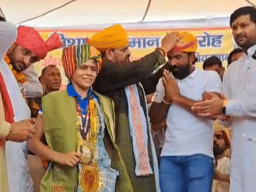पहलवान व भाजपा नेता योगेश्वर दत्त को सम्मानित करते बृजभूषण, उनके साथ पहलवान रचना परमार भी साफा पहने खड़ी हैं।