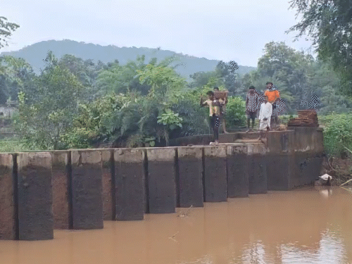 काम करने वाले मजदूर अपने सामान के साथ इस तरह से पार होते है।