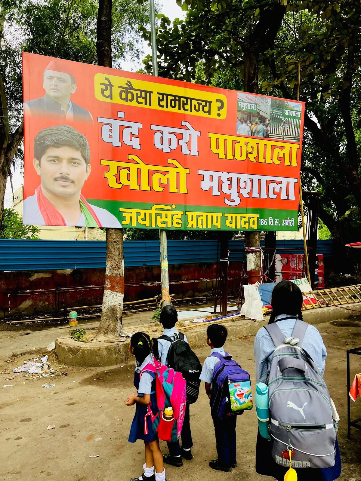 सपा कार्यालय के बाहर लगे होर्डिंग को स्कूल जा रहे बच्चों ने रुककर देखा।