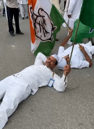 Congress workers lay down on the road during Protest on the Income Tax Golambar of Patna.