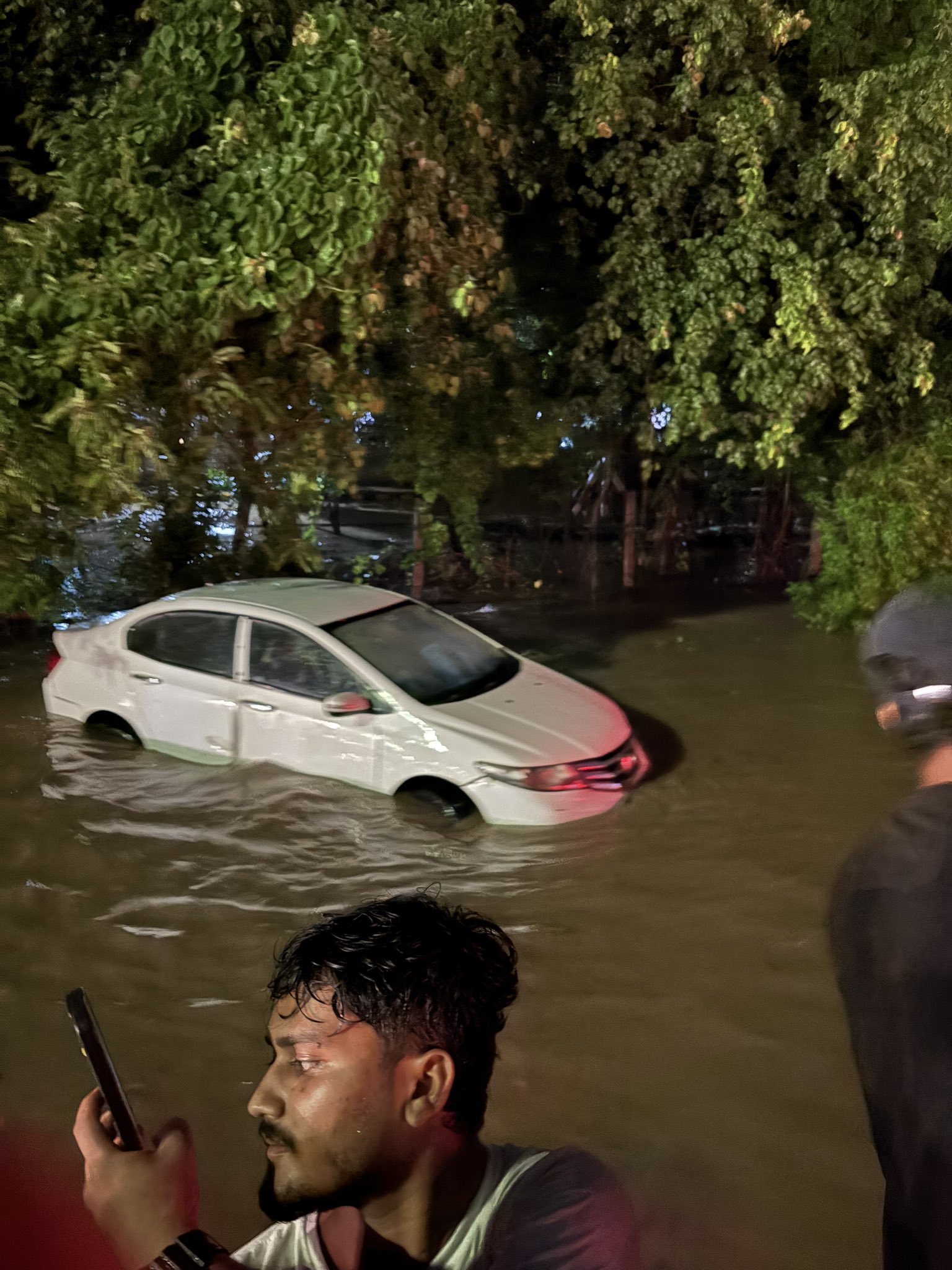गुरुग्राम में बारिश के दौरान फंसा युवक सेल्फी लेते हुए।