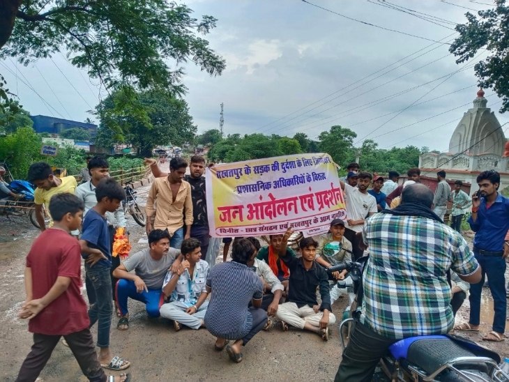 सड़क पर बैठे प्रदर्शनकारी, मंत्री का काफिला लौटा।