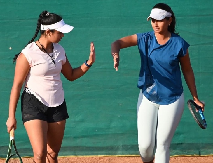 एक मैच के दौरान साथी खिलाड़ी से हाथ मिलाती राधिका (सफेद टीशर्ट।