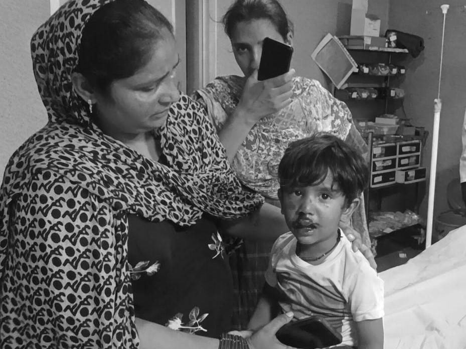 अस्पताल में महिलाओं के साथ मौजूद घायल बच्चा।
