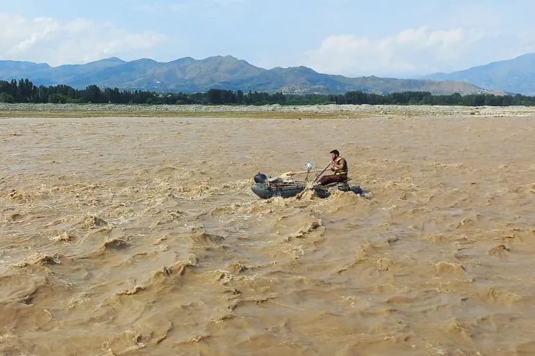 A rescue worker carrying a boat during the flood in the Jhelum River.