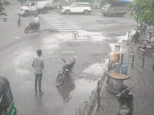 बाइक से उतरकर ट्रक के आने का इंतजार करता हुआ।