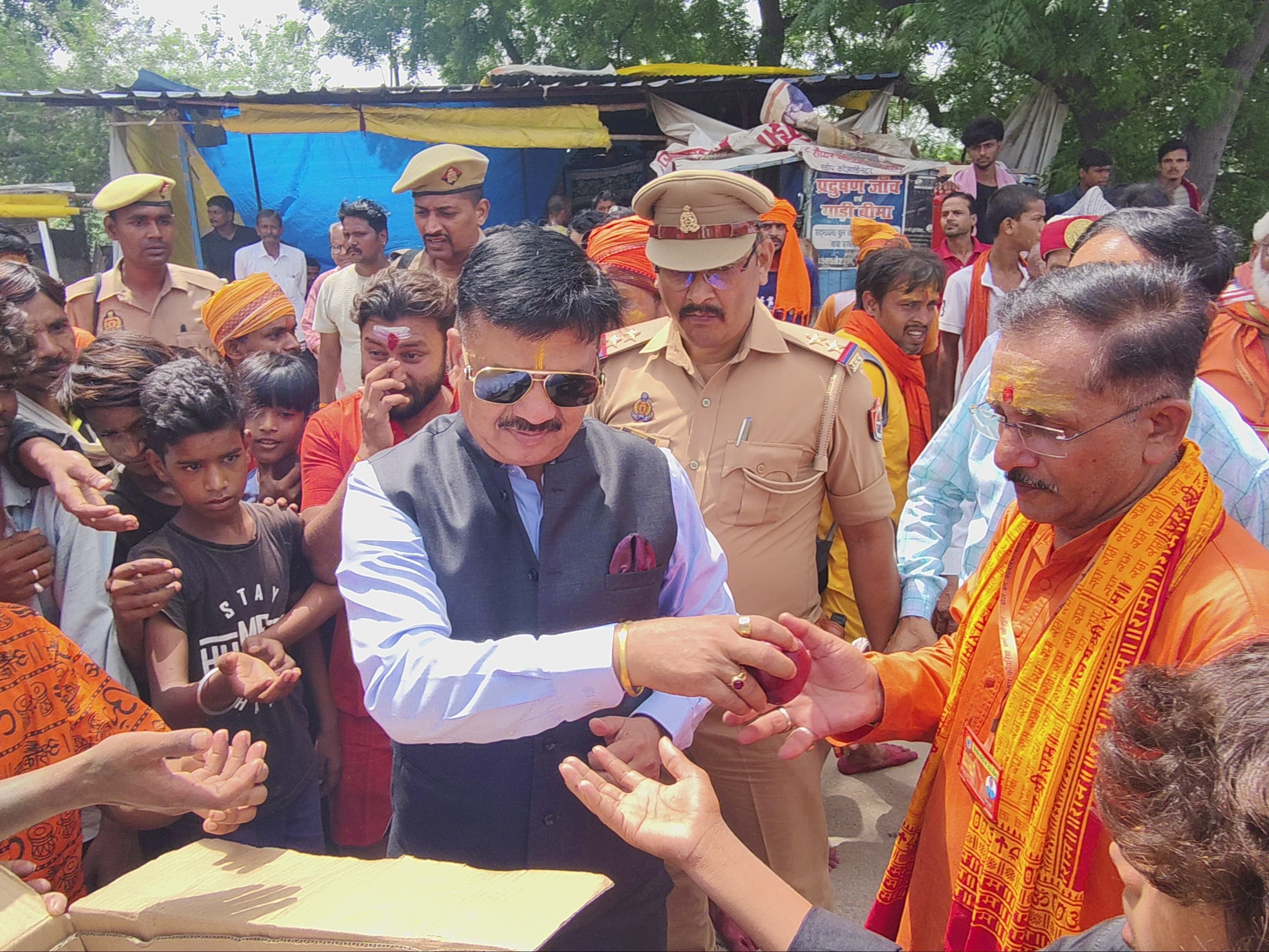 डीएम ने कांवड़ियों को फल वितरित किए।