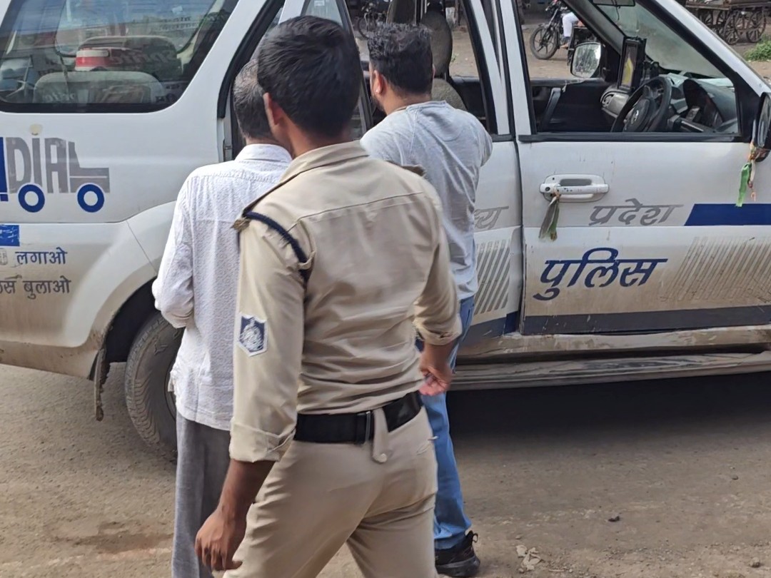 दुकानदार को थाने ले जाती पुलिस।