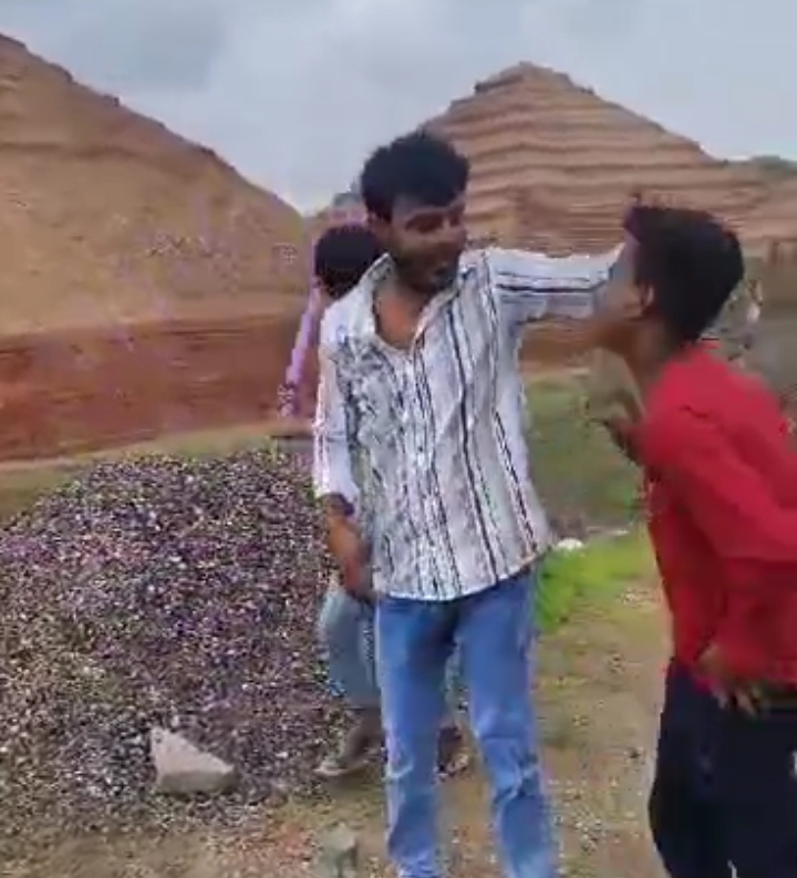 दूसरे युवक को पीटता हुआ।