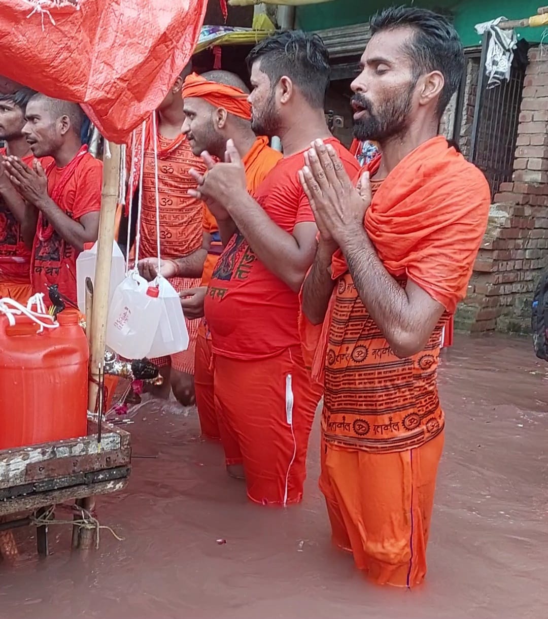 बाढ़ के पानी में खड़े कांवड़ की पूजा करते श्रद्धालु