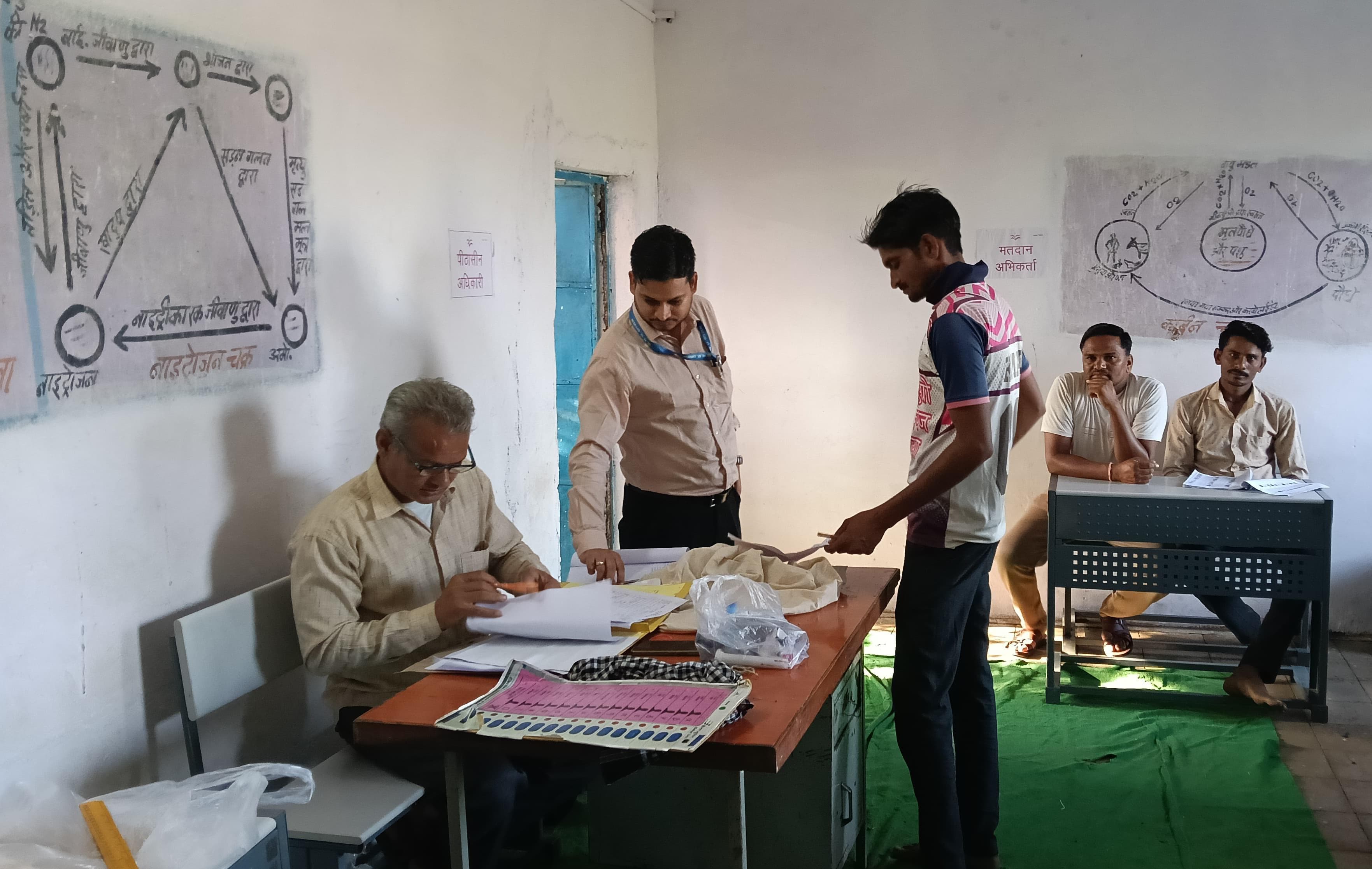 वोट डालने की प्रक्रिया करते मतदाता।