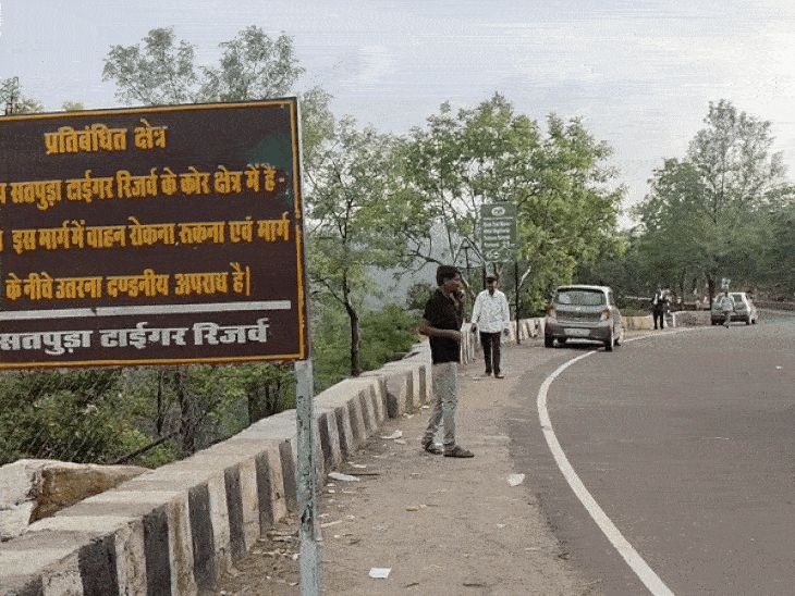 सड़क किनारे मोड़ पर गाड़ियां खड़ी कर रहे लोग।