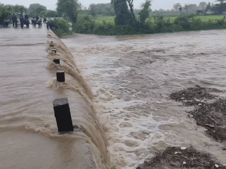 पुलिया के ऊपर से बह रहा पानी।
