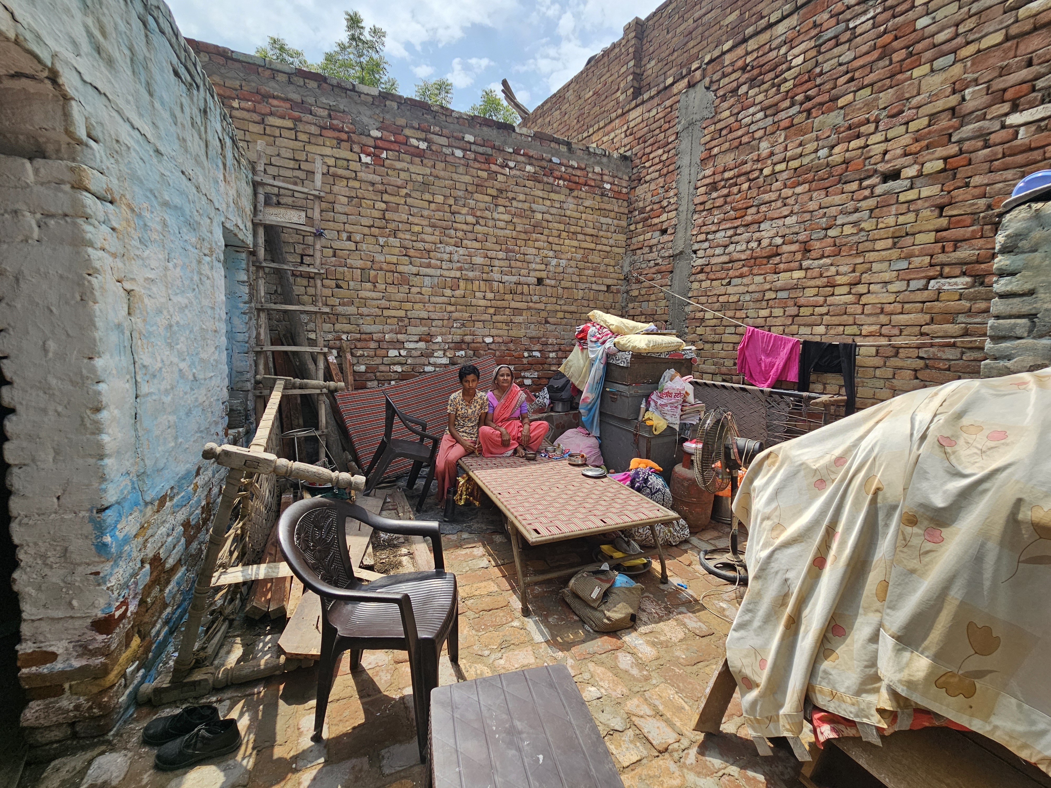 हादसे के बाद सामान के साथ बाहर बैठी दादी और पोती।